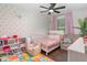 A cozy bedroom with a colorful alphabet rug, soft textures, and playful decor elements at 1033 Mccully Ct, Oviedo, FL 32765