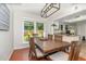 Dining area with a wooden table, modern light fixture, and a view into the kitchen at 1033 Mccully Ct, Oviedo, FL 32765