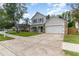 Two-story home with neutral siding, stone accents, a covered porch, and a driveway at 1033 Mccully Ct, Oviedo, FL 32765
