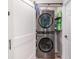 A compact laundry room featuring a stacked washer and dryer unit for efficient space-saving at 1033 Mccully Ct, Oviedo, FL 32765