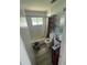 Modest bathroom with white tile, a combined tub and shower, and toilet with shelving unit at 1047 Clay Blvd, Eustis, FL 32726