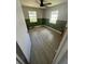 Empty bedroom with wood-look tile, a ceiling fan, and paneled walls beneath the windows at 1047 Clay Blvd, Eustis, FL 32726