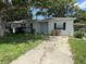 Charming single-story home featuring a concrete driveway and mature trees at 1047 Clay Blvd, Eustis, FL 32726