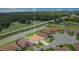 Aerial view of neighborhood home with lawn, landscaping, and water views at 1104 Sawgrass Dr, Winter Haven, FL 33884