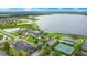 Stunning aerial view of clubhouse, lake, tennis courts, pool and golf course in community at 1104 Sawgrass Dr, Winter Haven, FL 33884