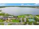Scenic aerial view of the clubhouse, pool, tennis courts and parking lot by a large lake at 1104 Sawgrass Dr, Winter Haven, FL 33884