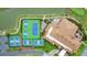 A bird's-eye view displays the tennis courts and clubhouse with greenery at 1104 Sawgrass Dr, Winter Haven, FL 33884