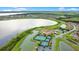 A scenic aerial view features the clubhouse, tennis courts, and a large lake at 1104 Sawgrass Dr, Winter Haven, FL 33884