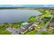 Community clubhouse with pool, manicured lawns, tennis courts and parking with lake view at 1104 Sawgrass Dr, Winter Haven, FL 33884
