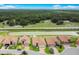 An aerial view of homes along a pond, showcasing green spaces at 1104 Sawgrass Dr, Winter Haven, FL 33884