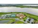 The aerial view highlights tennis courts and a clubhouse by a lake at 1104 Sawgrass Dr, Winter Haven, FL 33884