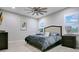 Spacious bedroom with wood-look floors, ceiling fan, plantation shutters and modern decor at 1104 Sawgrass Dr, Winter Haven, FL 33884