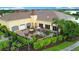 View of the clubhouse, patio with seating, manicured landscaping and garden at 1104 Sawgrass Dr, Winter Haven, FL 33884