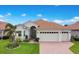 Charming single-story home with well-manicured lawn, mature landscaping, and a three-car garage at 1104 Sawgrass Dr, Winter Haven, FL 33884