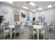 Bright meeting room featuring tables, chairs, a ceiling fan, and a large television for presentations at 1104 Sawgrass Dr, Winter Haven, FL 33884