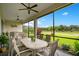 Enclosed patio featuring ceiling fans, a table and views of the well maintained backyard at 1104 Sawgrass Dr, Winter Haven, FL 33884