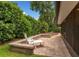 Secluded backyard patio featuring a lounge chair, brick pavers, and privacy landscaping at 1165 Baltic Ln, Winter Springs, FL 32708