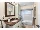 Bathroom featuring a vanity with granite countertops, framed mirror, and tub with tile surround at 1165 Baltic Ln, Winter Springs, FL 32708