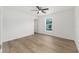 Bright bedroom featuring wood floors, a ceiling fan, a closet, and a window with a view at 13031 Ne 7Th Loop, Silver Springs, FL 34488