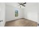 Bright bedroom with wood-look flooring, ceiling fan, and a scenic view at 13031 Ne 7Th Loop, Silver Springs, FL 34488