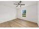 Bright bedroom with wood-look flooring, ceiling fan, and a view of the outdoors at 13031 Ne 7Th Loop, Silver Springs, FL 34488