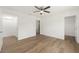 Spacious bedroom features wood-look floors, ceiling fan, and multiple doorways at 13031 Ne 7Th Loop, Silver Springs, FL 34488