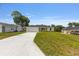 A single-story home with a large front lawn and long concrete driveway offers ample parking space at 13031 Ne 7Th Loop, Silver Springs, FL 34488