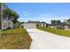 A single-story home with a large front lawn and long concrete driveway offers ample parking space at 13031 Ne 7Th Loop, Silver Springs, FL 34488