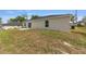 Home exterior featuring a sliding glass door and window overlooking the yard with space for outdoor activities at 13031 Ne 7Th Loop, Silver Springs, FL 34488