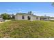 Exterior view of a single-story home showcasing a well-maintained yard with a sliding glass door at 13031 Ne 7Th Loop, Silver Springs, FL 34488