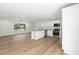 Open floor plan featuring wood floors, a kitchen island, stainless steel appliances, and natural lighting at 13031 Ne 7Th Loop, Silver Springs, FL 34488