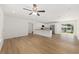 Bright living room featuring wood floors, a ceiling fan, and an open floor plan into the kitchen at 13031 Ne 7Th Loop, Silver Springs, FL 34488