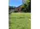 View of the side and backyard with flowering bushes, lush grass, and some fencing at 1307 Mabbette St, Kissimmee, FL 34741