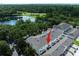 Aerial view of townhouse complex with a pond, mature trees and lush landscaping at 14128 Avenue Of The Grvs, Winter Garden, FL 34787
