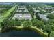 Aerial view of townhouse community surrounded by mature trees and a scenic pond at 14128 Avenue Of The Grvs, Winter Garden, FL 34787