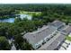 Aerial view of townhouse complex with a pond, mature trees and lush landscaping at 14128 Avenue Of The Grvs, Winter Garden, FL 34787
