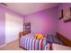 Bright bedroom with a colorful striped comforter and a well-organized closet at 14128 Avenue Of The Grvs, Winter Garden, FL 34787