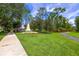 Landscaped community entrance with manicured lawn and shade trees at 14128 Avenue Of The Grvs, Winter Garden, FL 34787