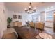 Open dining area showcasing a wooden table with upholstered chairs, a chandelier, and seamless access to the kitchen at 14128 Avenue Of The Grvs, Winter Garden, FL 34787