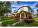 Townhouse exterior featuring manicured lawn and covered front porch at 14128 Avenue Of The Grvs, Winter Garden, FL 34787