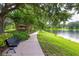 Scenic lakeside view of a park featuring a gazebo, park bench, and paved pathway, perfect for relaxing strolls at 14128 Avenue Of The Grvs, Winter Garden, FL 34787