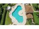 Aerial view of a community pool featuring a unique layout, sunbathing deck, and mature landscaping at 1509 Cedar Lake Dr, Orlando, FL 32824