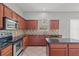 Well-equipped kitchen features wooden cabinets, black countertops, stainless steel appliances, and tile flooring at 1509 Cedar Lake Dr, Orlando, FL 32824