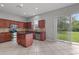 Open kitchen area with wood cabinets, tile flooring, granite countertops, stainless steel appliances, and access to the backyard at 1509 Cedar Lake Dr, Orlando, FL 32824
