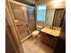 Bathroom featuring glass shower, a granite vanity, and earth tone tile flooring at 1509 Huntington St, Deltona, FL 32725