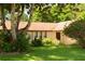 The house features a well-manicured lawn with mature trees and shrubs surrounding the property at 1509 Huntington St, Deltona, FL 32725