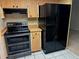 A kitchen boasting updated black appliances and wood cabinets for plenty of storage space at 1509 Huntington St, Deltona, FL 32725