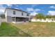 Backyard with grass, partial fire pit, screened-in porch, and white vinyl fencing at 16053 Wilkinson Dr, Clermont, FL 34714