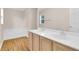 Bathroom with double sink vanity, garden tub, wood-look floors, and a large mirror at 16053 Wilkinson Dr, Clermont, FL 34714