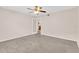 Spacious bedroom with neutral carpet and glass door to the kitchen at 16053 Wilkinson Dr, Clermont, FL 34714